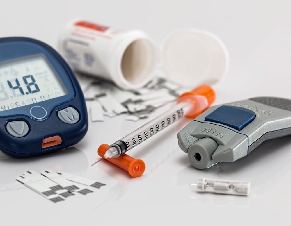 Diabetes care tools including glucose meter, insulin syringe, and test strips.