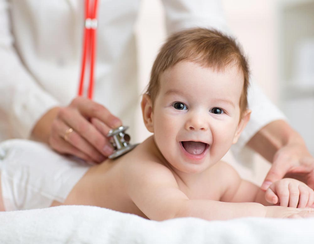 Smiling baby during a medical check-up.